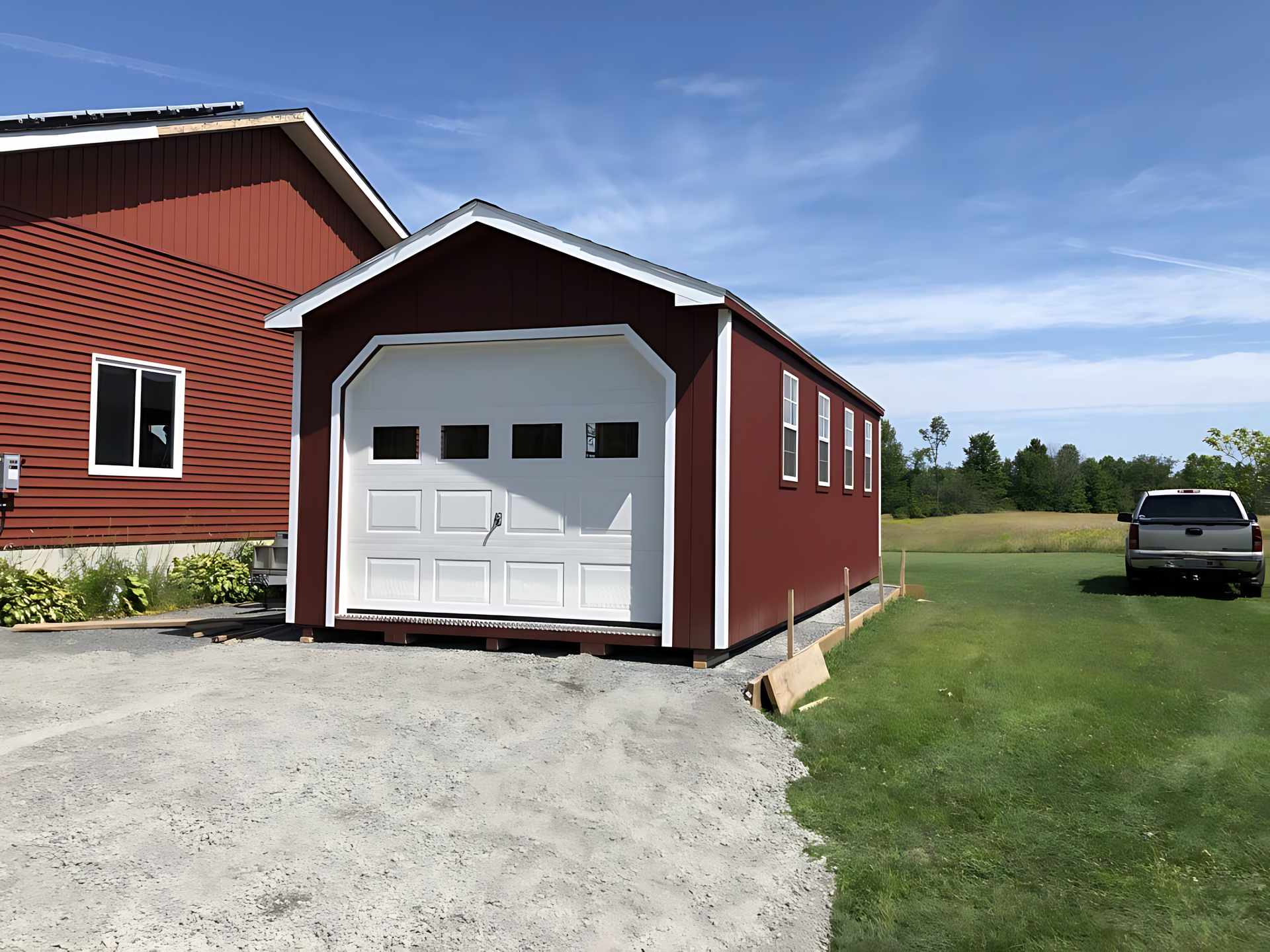 A red garage with a white door and a truck parked in front of it