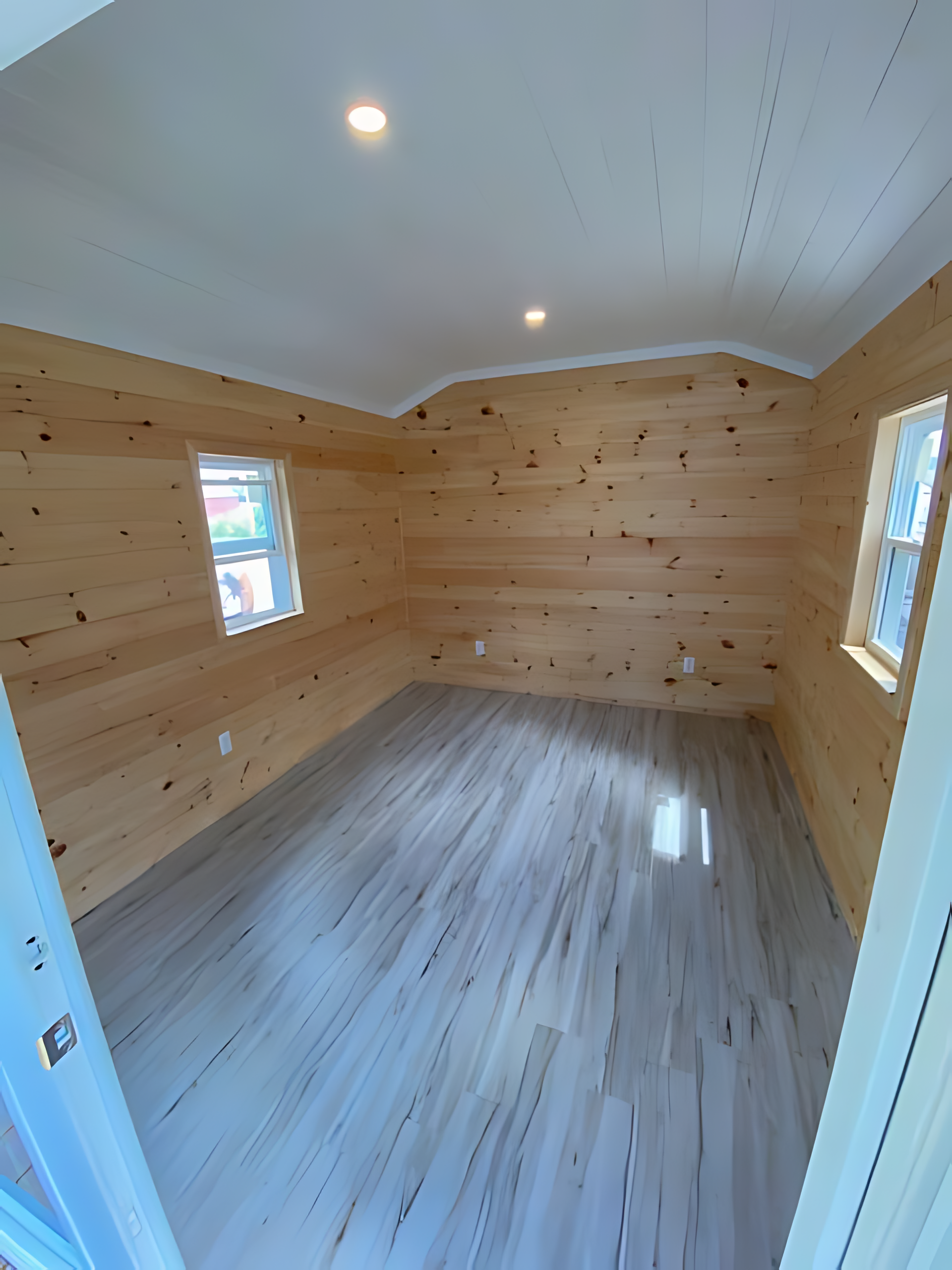 An empty room with wooden walls and a white floor