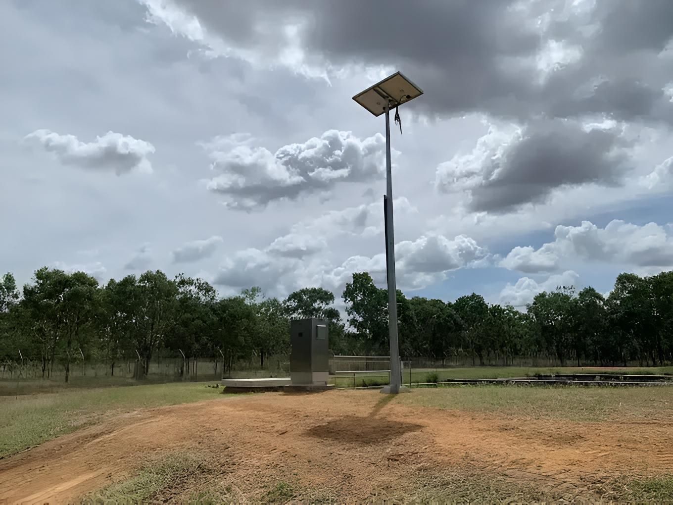 A Solar Panel Is Sitting On Top Of A Pole In A Field — CCD Electrical In Berrimah, NT