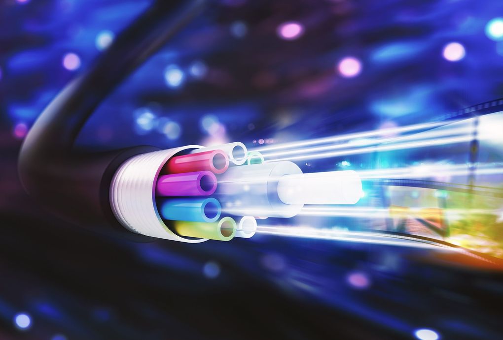 Un primer plano de un cable de fibra óptica del que sale luz.