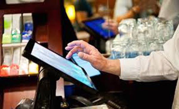 Un hombre está usando una tableta en un restaurante.