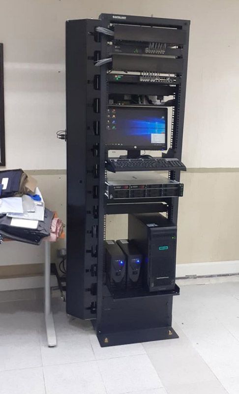 Una computadora está colocada encima de un estante en una habitación.