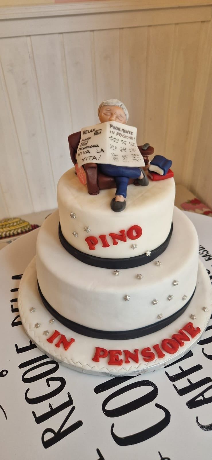 Torta a due piani con una figura anziana. Sulla torta è scritto