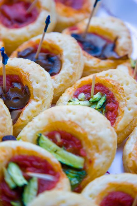 Primo piano di antipasti al forno con vari condimenti fissati con stuzzicadenti; vari colori.