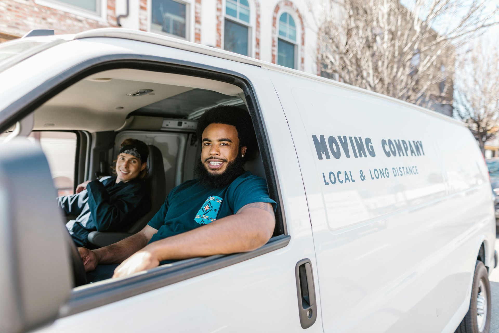Two men are sitting in a moving company van