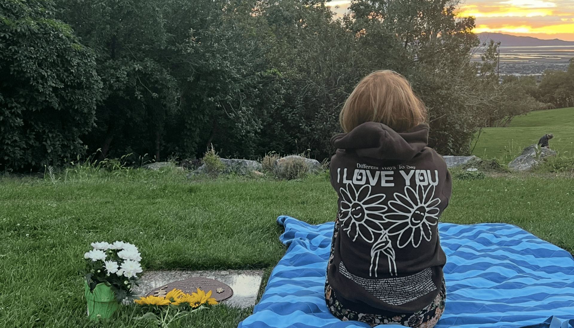 Tiara Monson sitting by a graveside at sunset