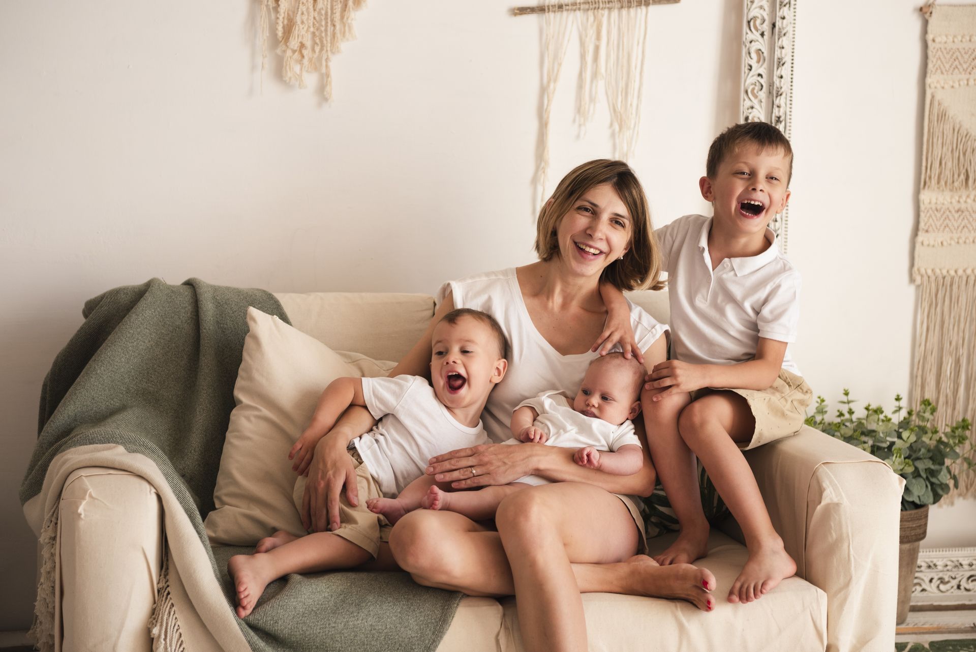 a mother laughing with her newborn and two older children
