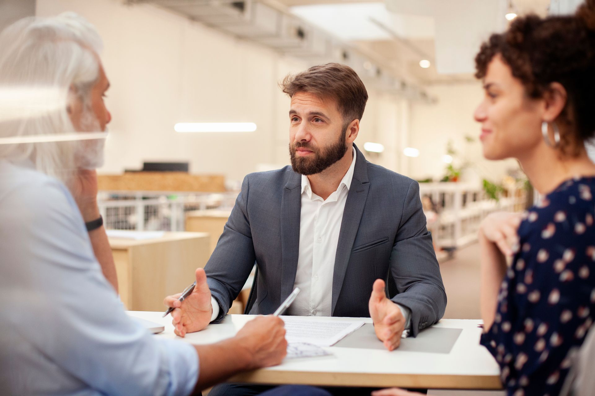 Business meeting with handshake across a desk and documents.