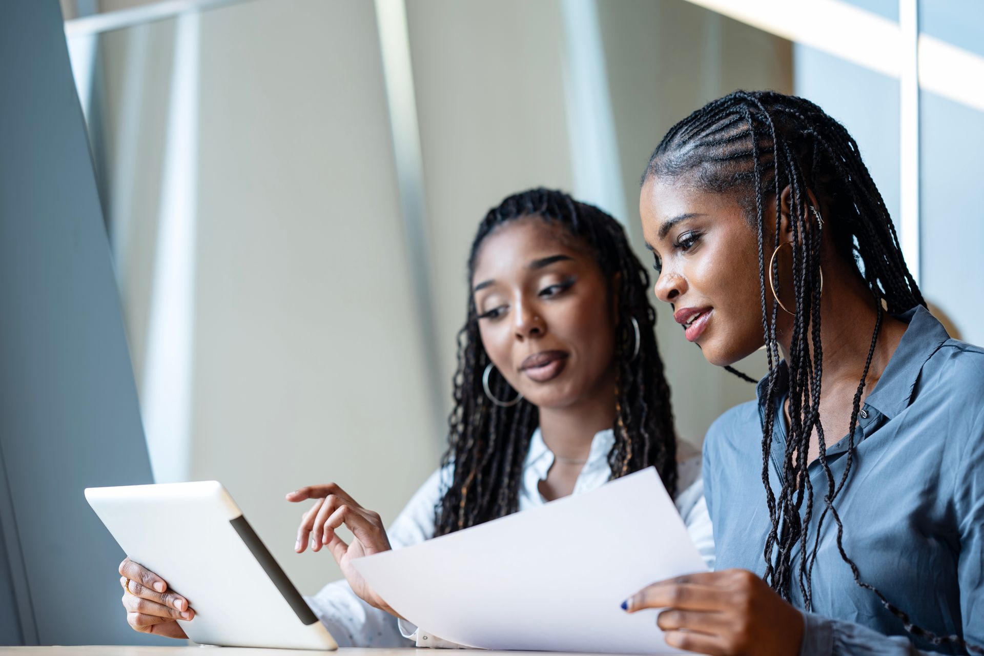 Two women in a meeting reviewing some documents.