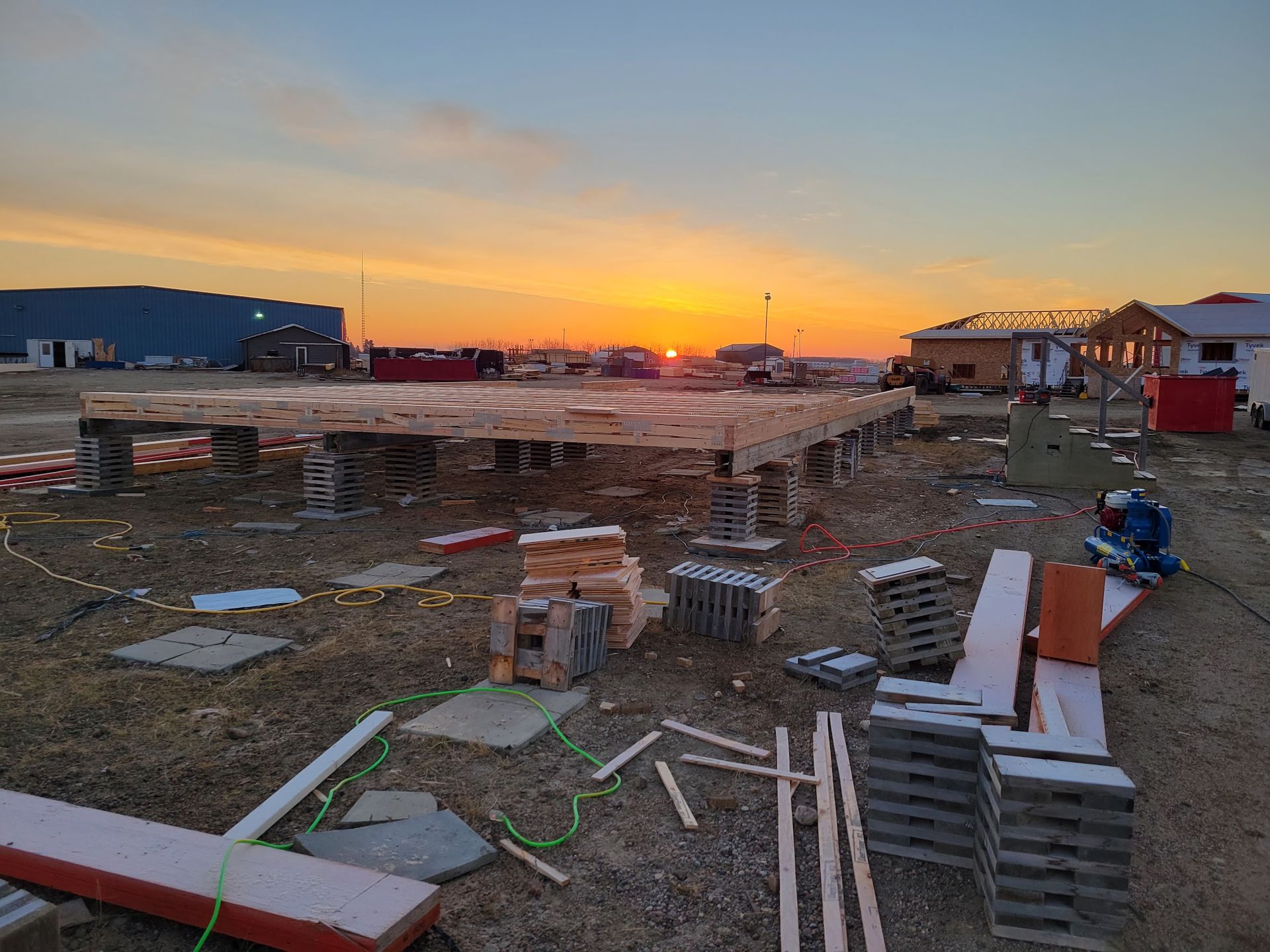 A construction site with a sunset in the background.