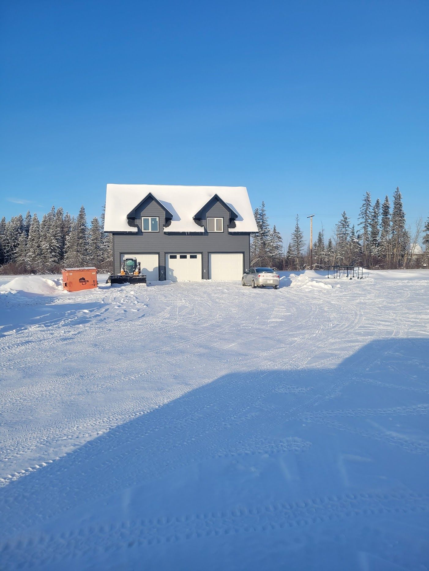 A house is covered in snow in a snowy field