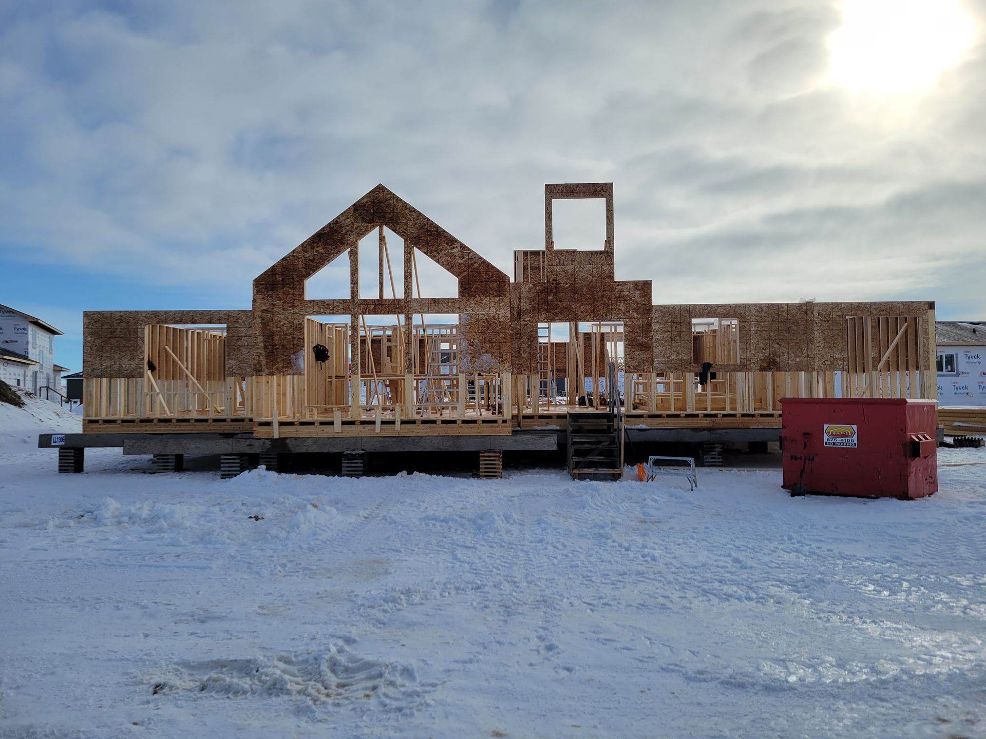A large wooden house is being built in the snow.