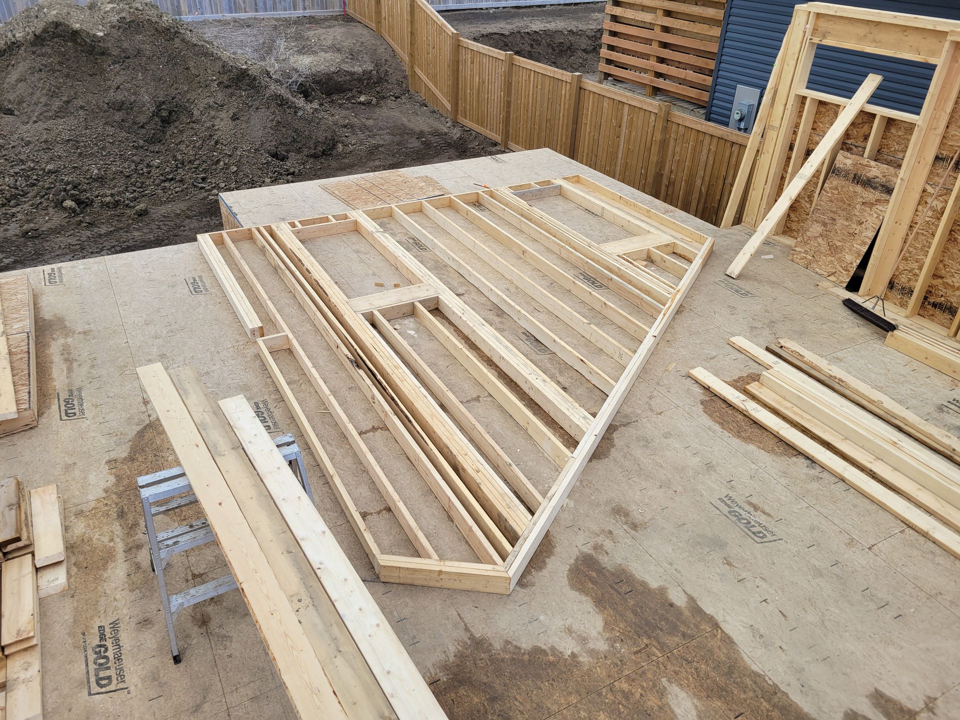 A pile of wood is sitting on the ground in a construction site.