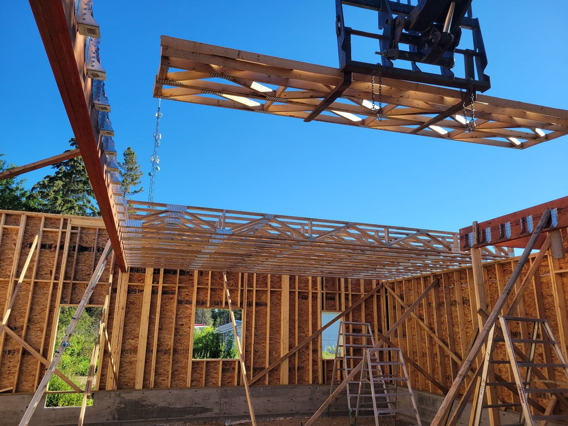 A large piece of wood is being lifted into the air by a crane.