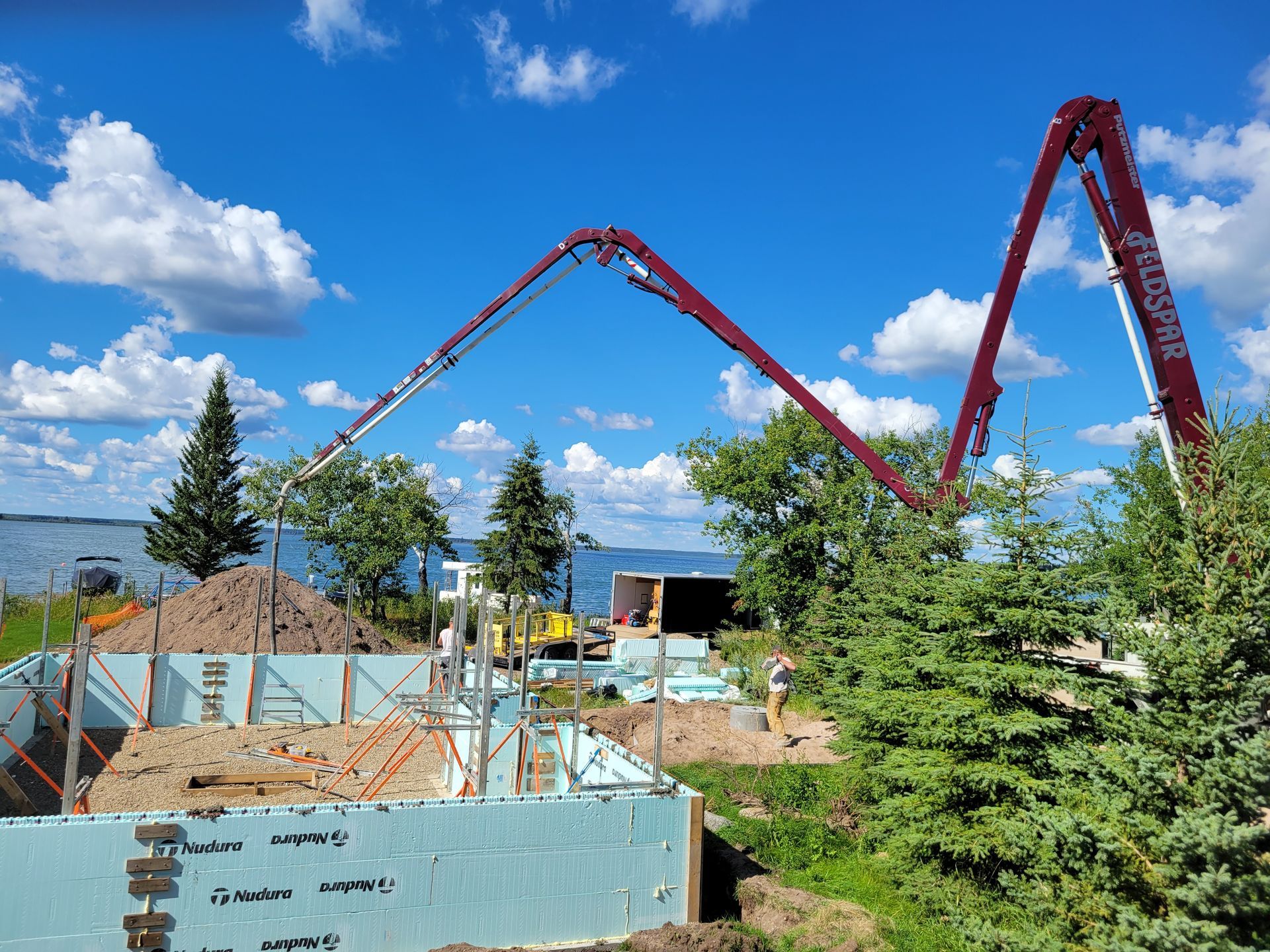 A concrete pump is being used to pour concrete into a building under construction.