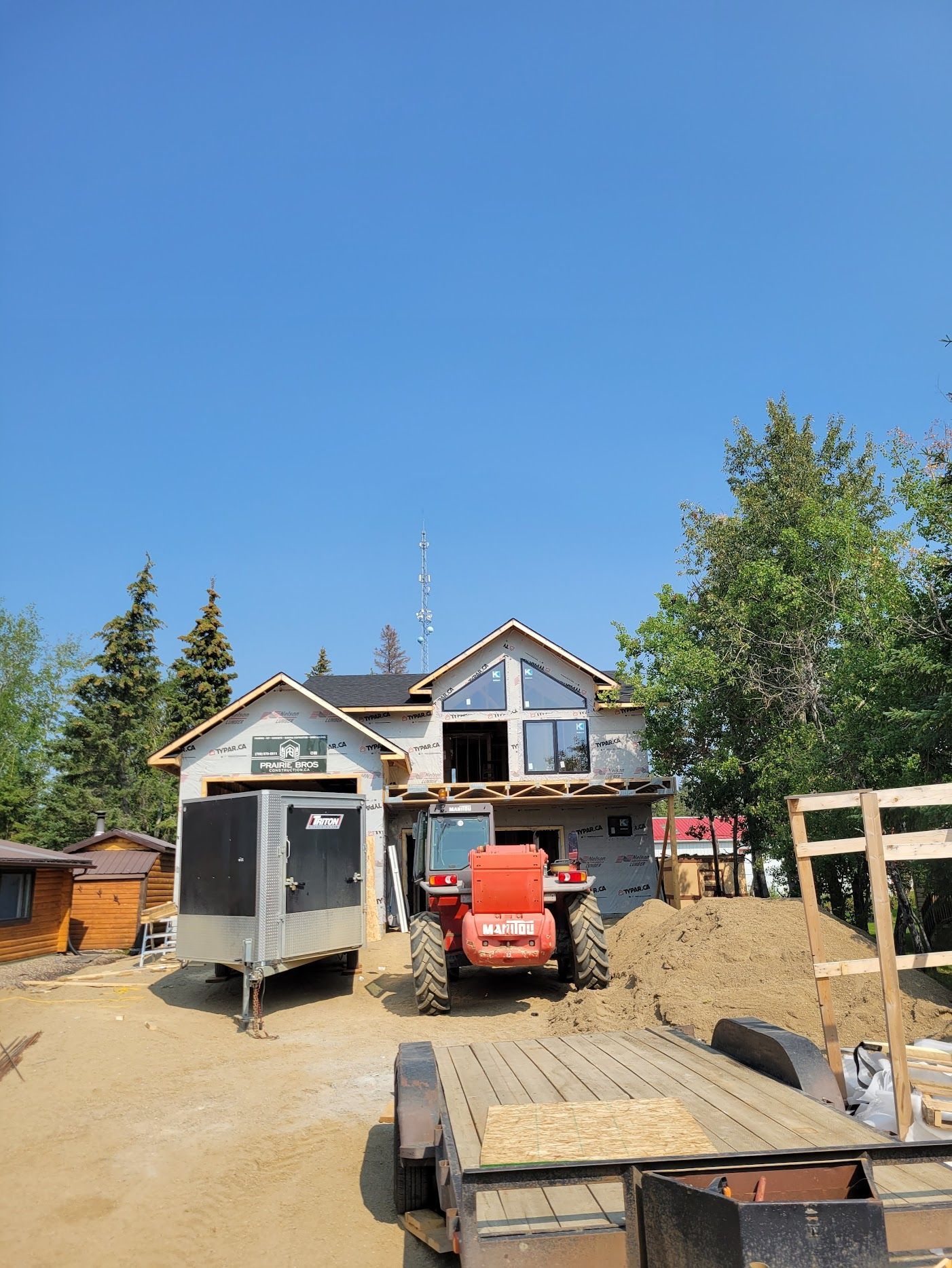 A tractor is parked in front of a house under construction
