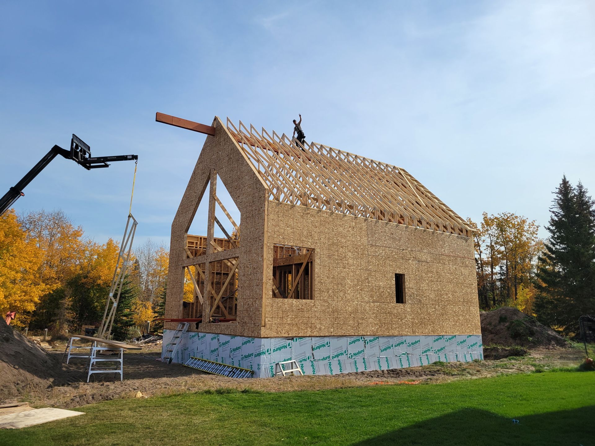 A house is being built with a crane on top of it.