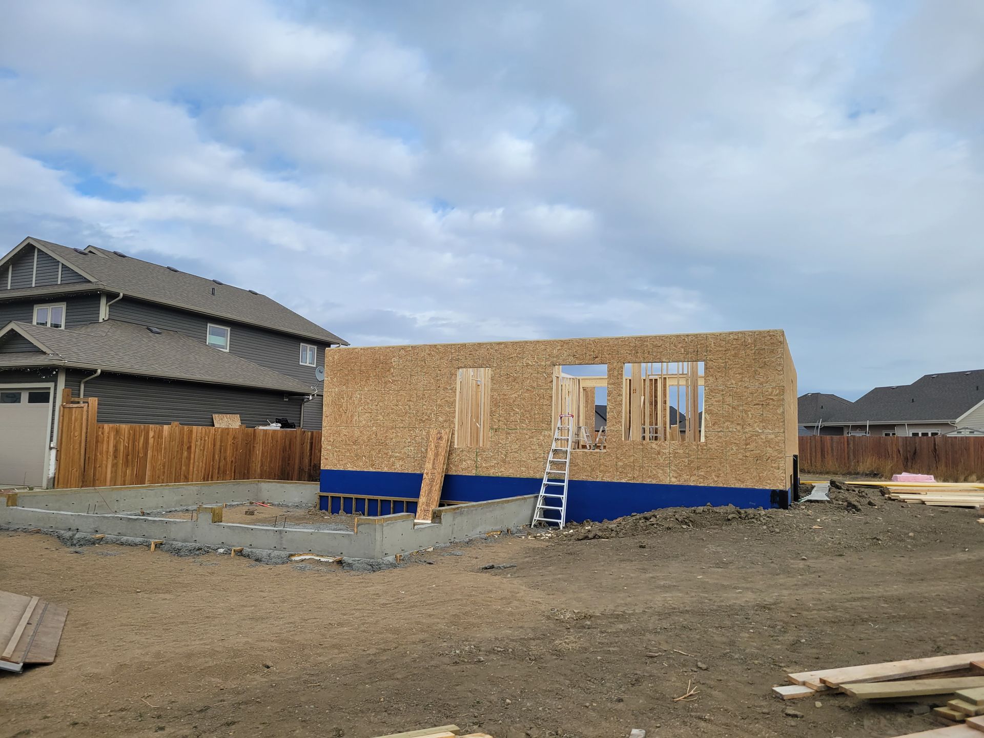 A house is being built in the middle of a dirt field.
