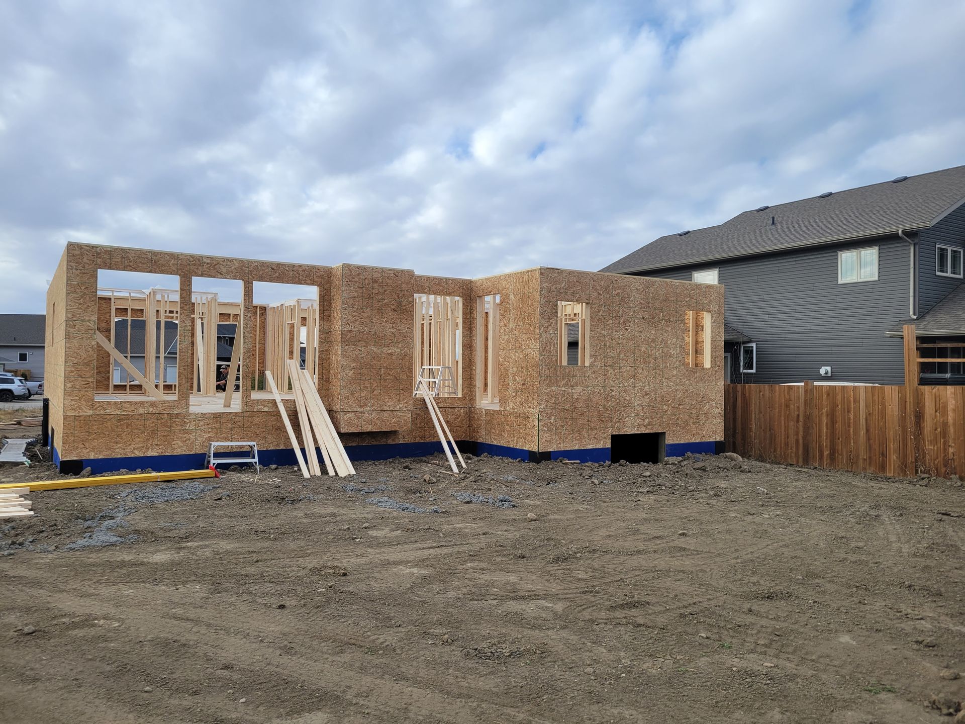 A house is being built in a dirt field.