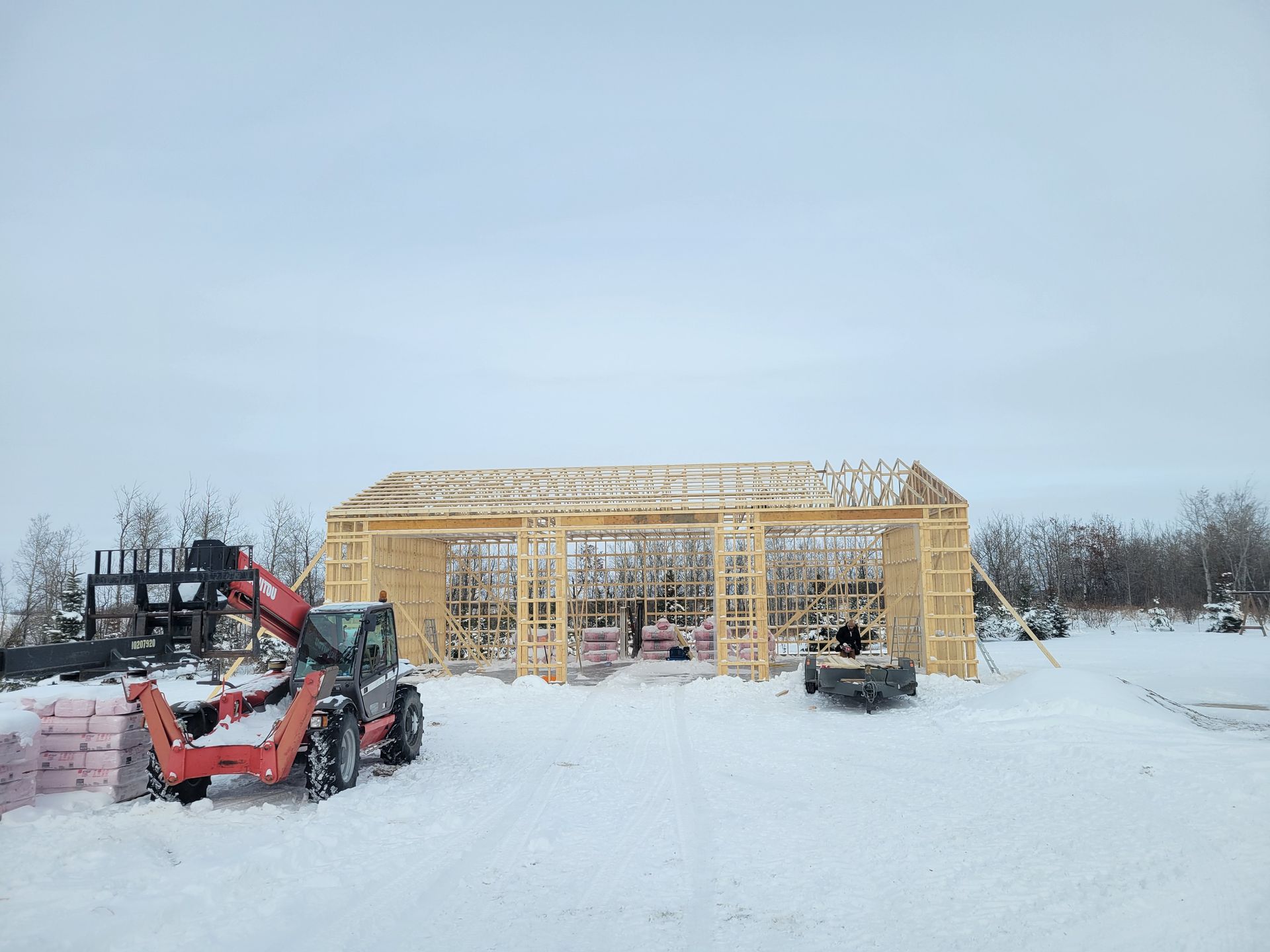 A large wooden structure is being built in the snow.