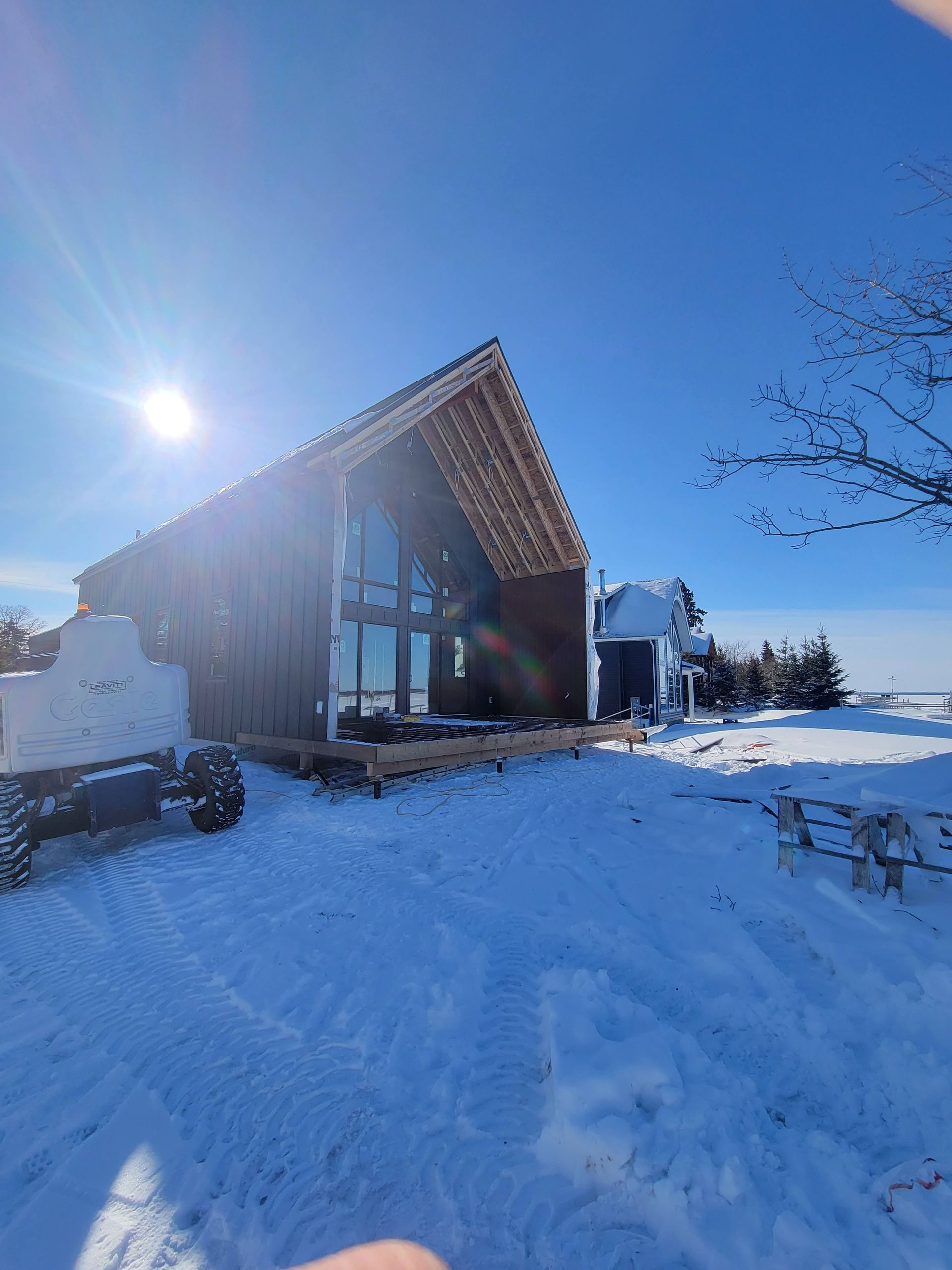 A house is covered in snow on a sunny day.