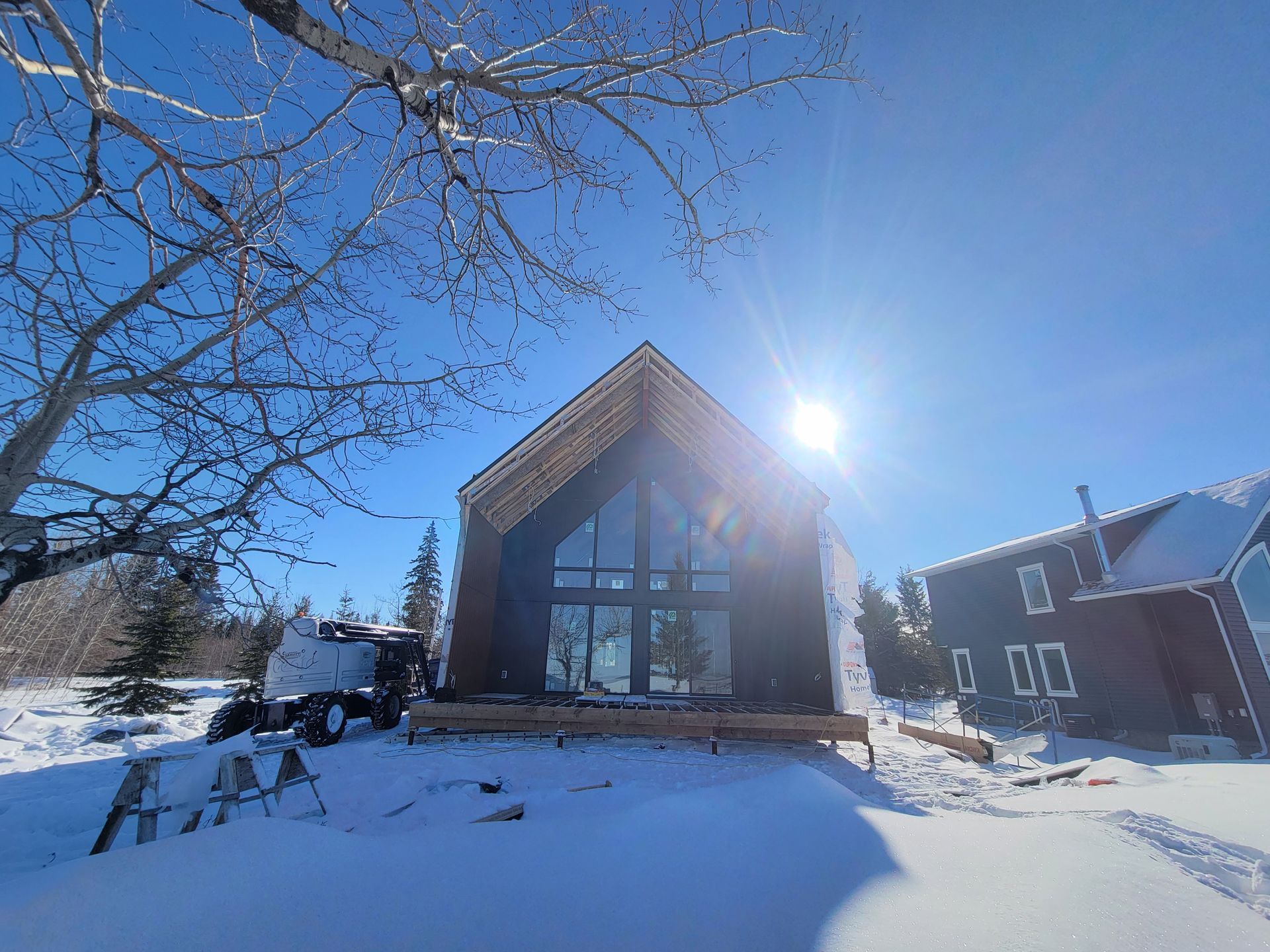 A house is being built in the snow and the sun is shining through the windows.