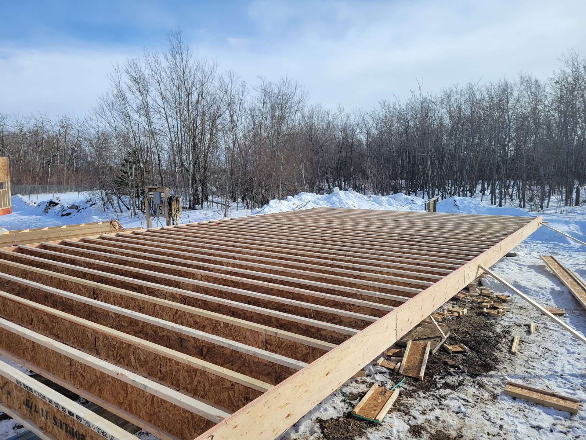 A wooden floor is being built in the snow.