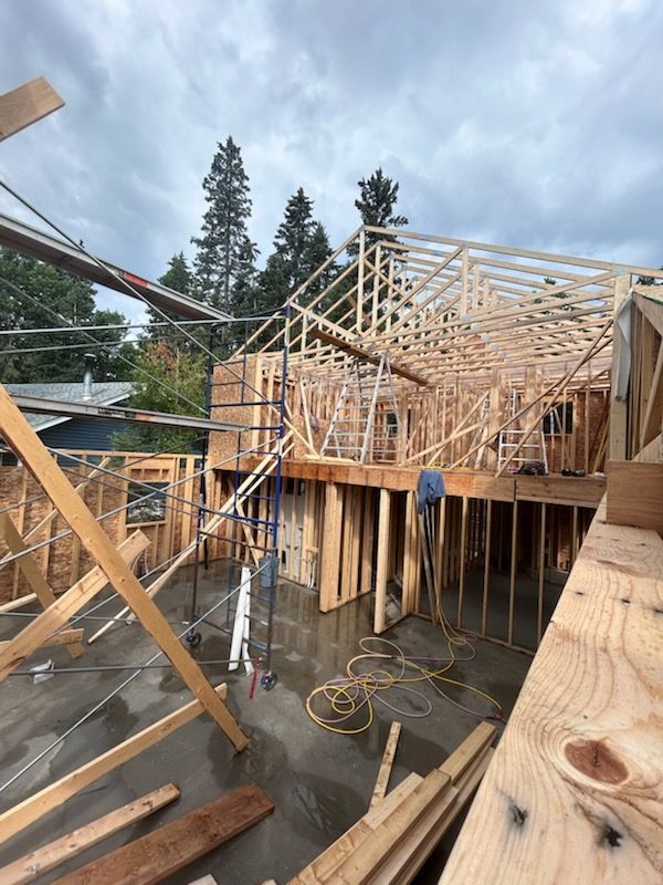 Construction site: wooden frame of a house under cloudy skies.