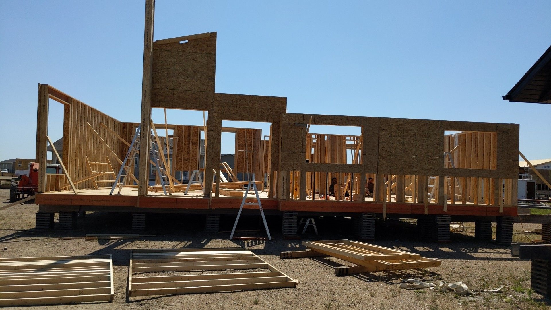 A large wooden house is being built in the desert