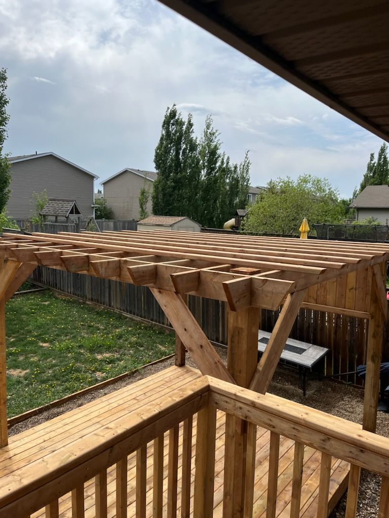 A wooden pergola is sitting on top of a wooden deck.