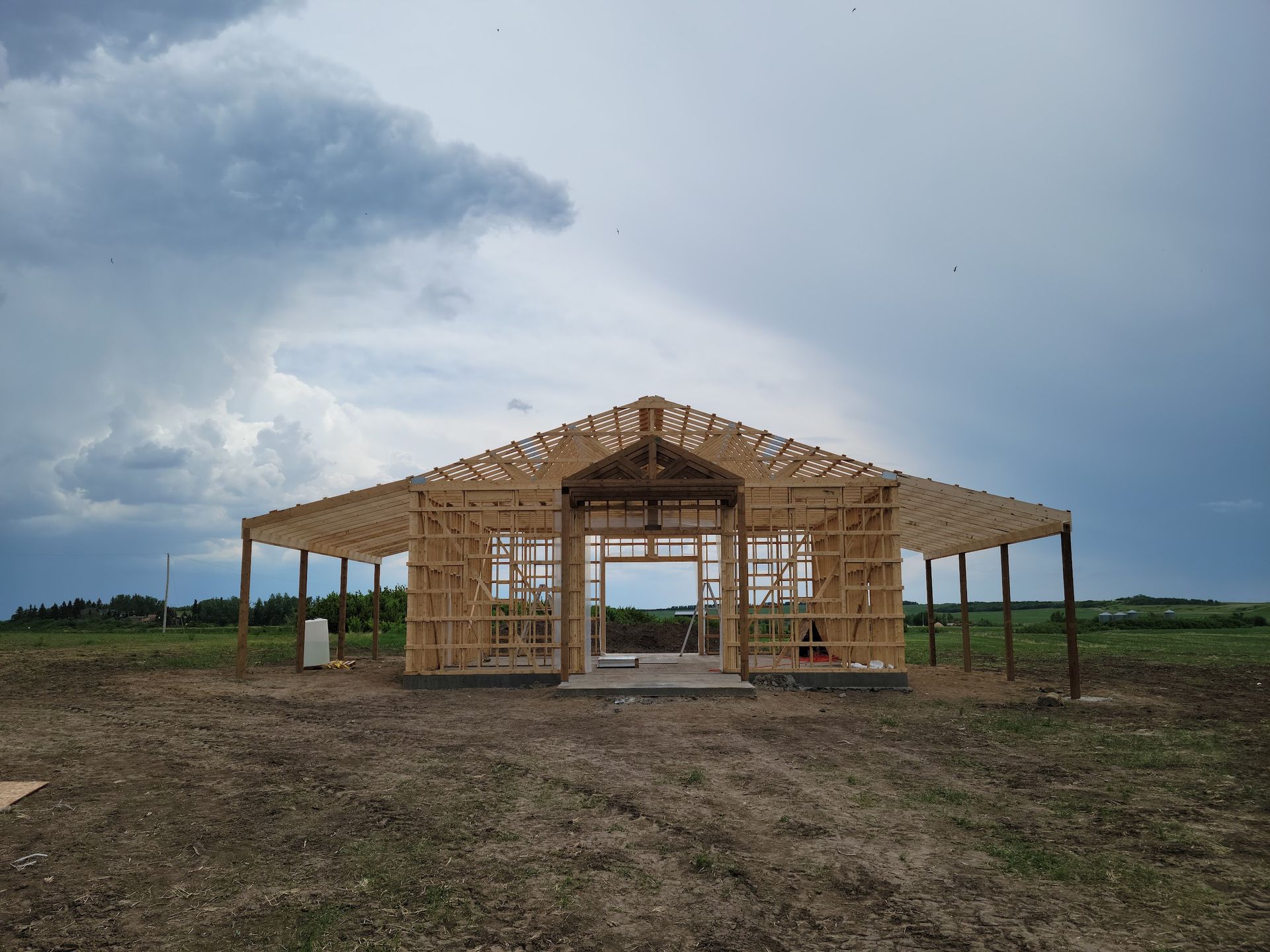 A large wooden structure is being built in a field