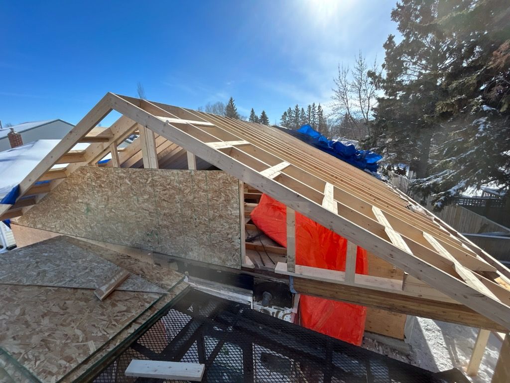The roof of a house is being built in the snow.