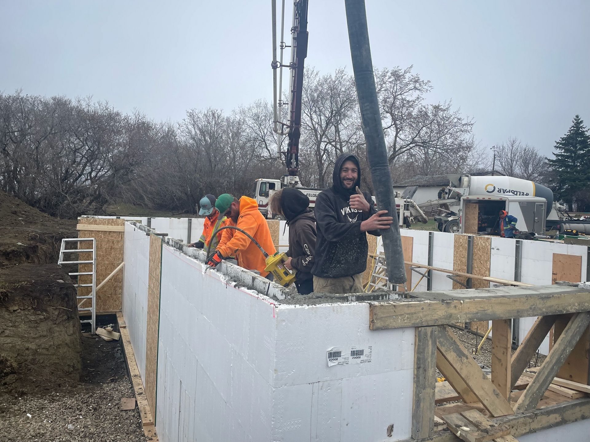 A group of construction workers are working on a wall.