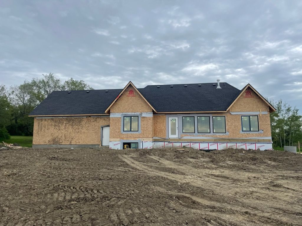 A house is being built in a dirt field.