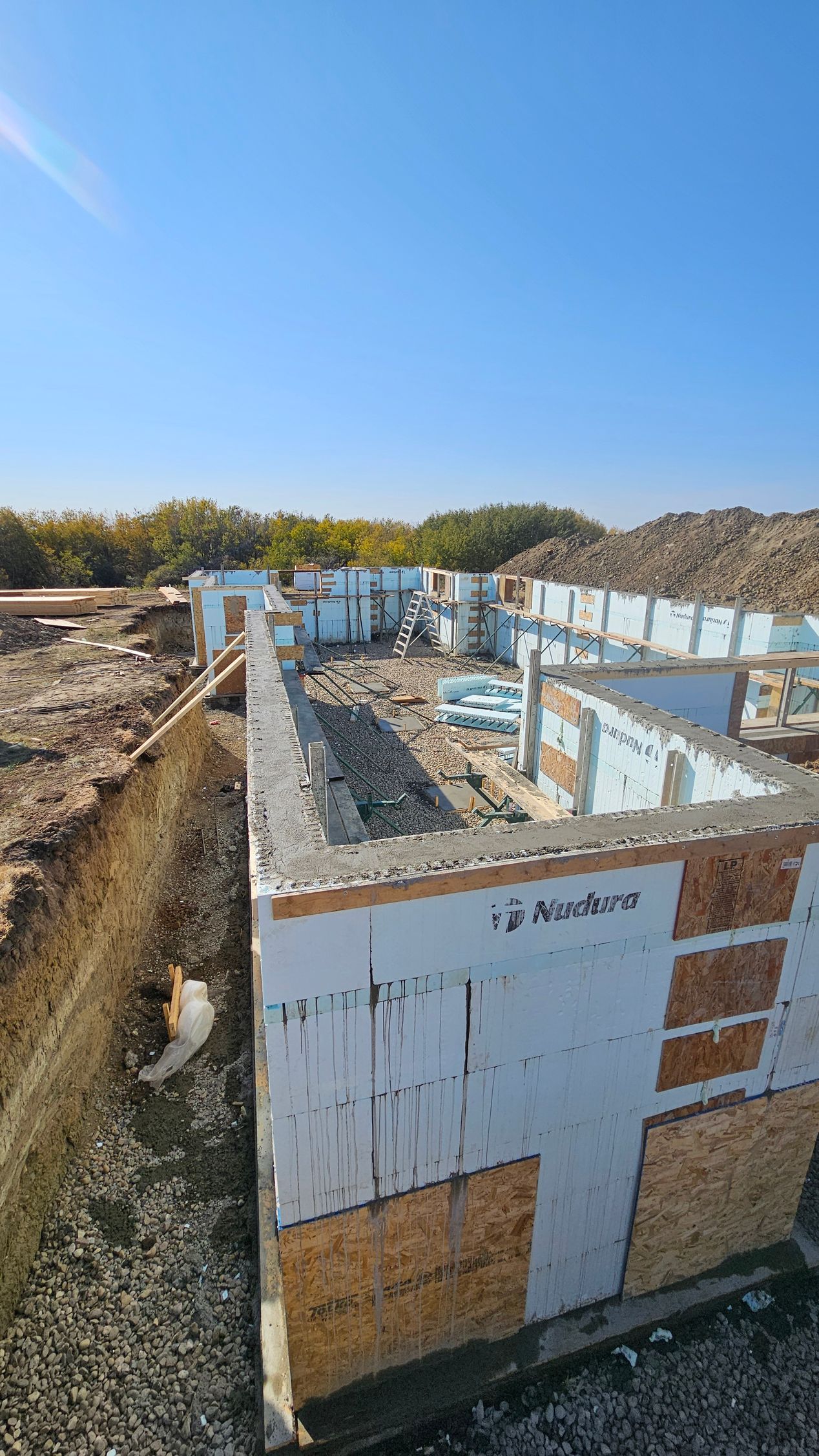 Foundation of a building under construction, made with foam blocks and concrete; sunny day.