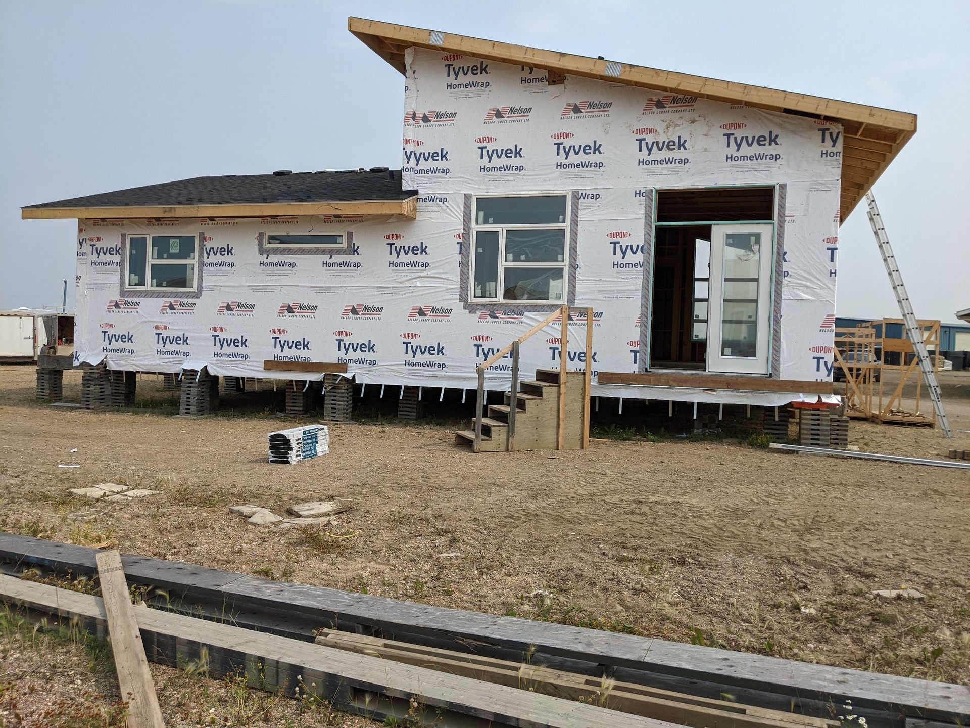 A small house is being built in the middle of a field.
