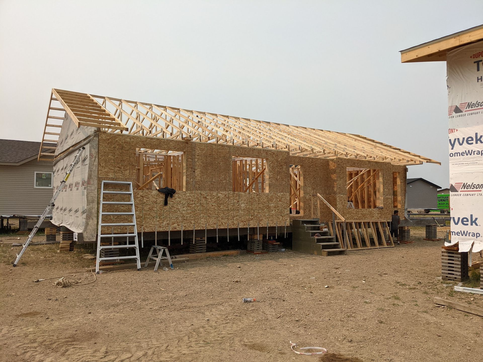 A house is being built in a dirt field.