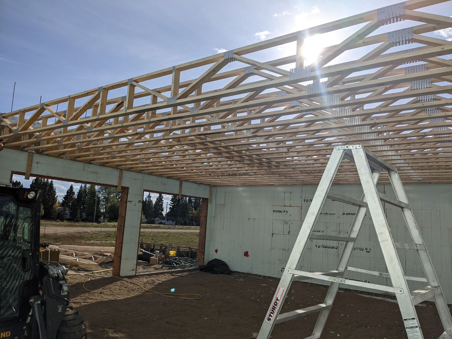A ladder is sitting in front of a building under construction.