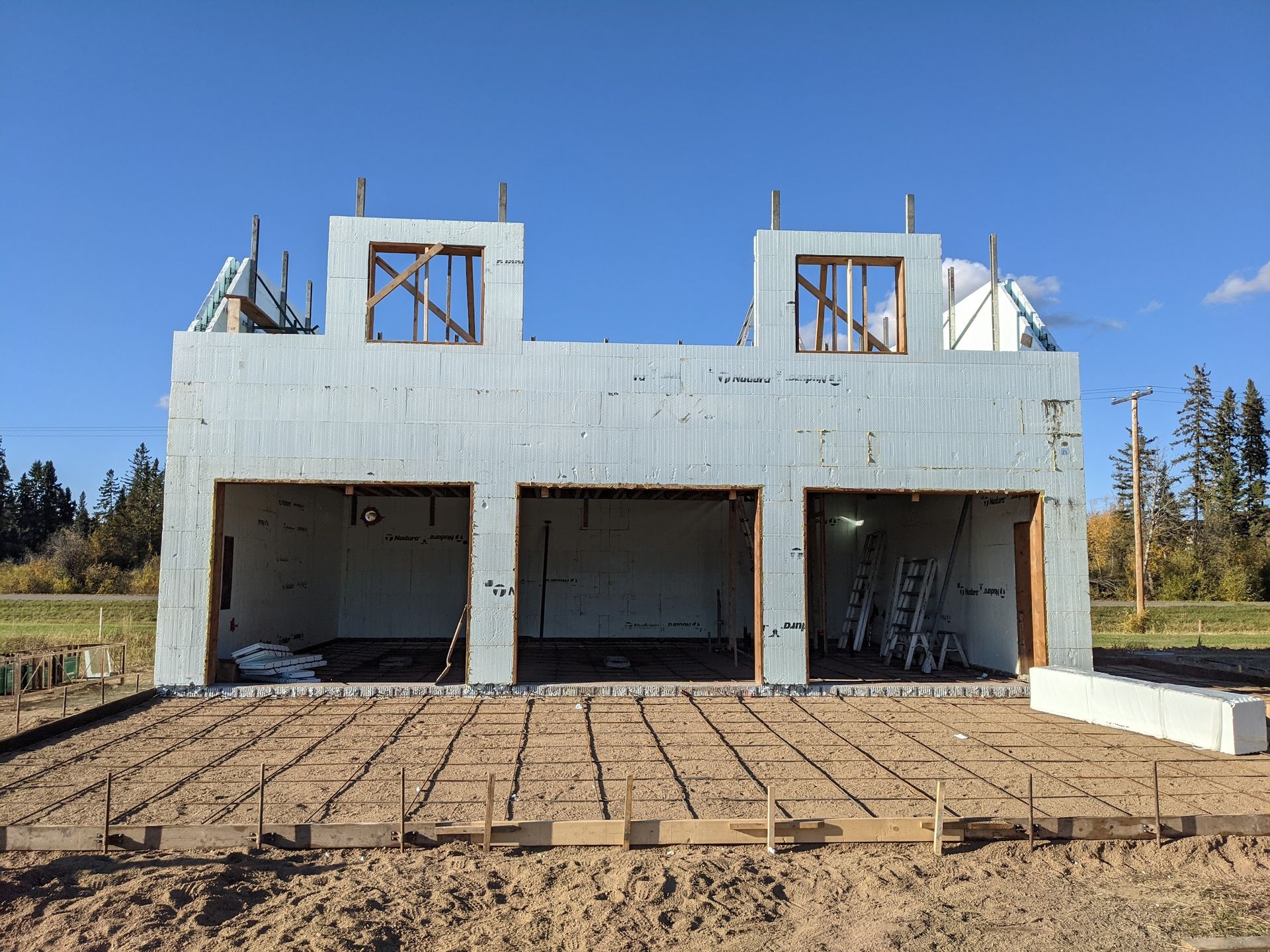 A house is being built in the middle of a dirt field.