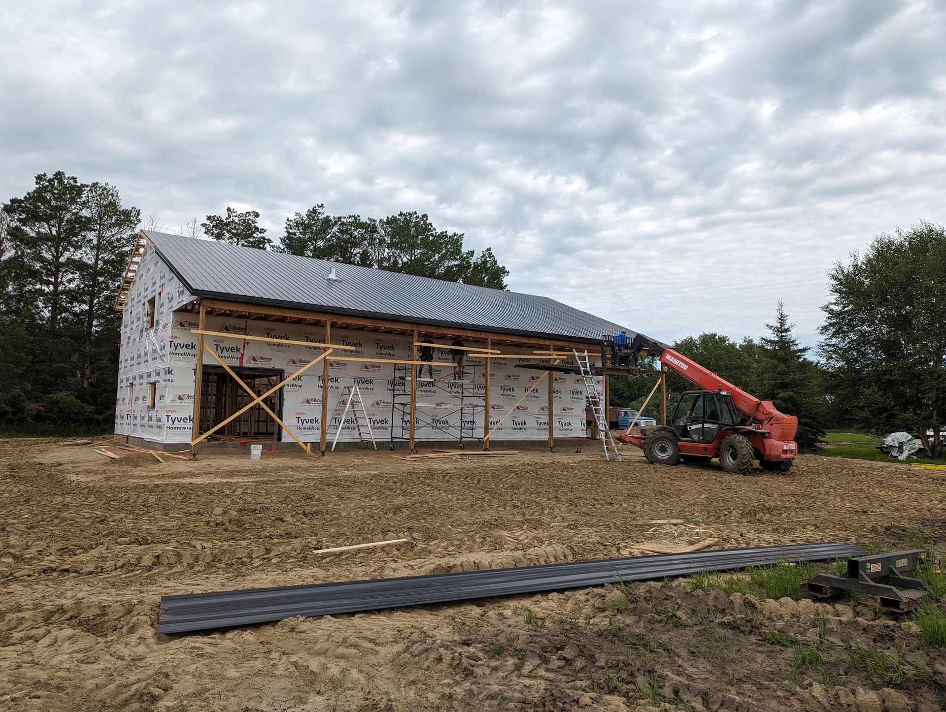 A large building is being built in a dirt field.