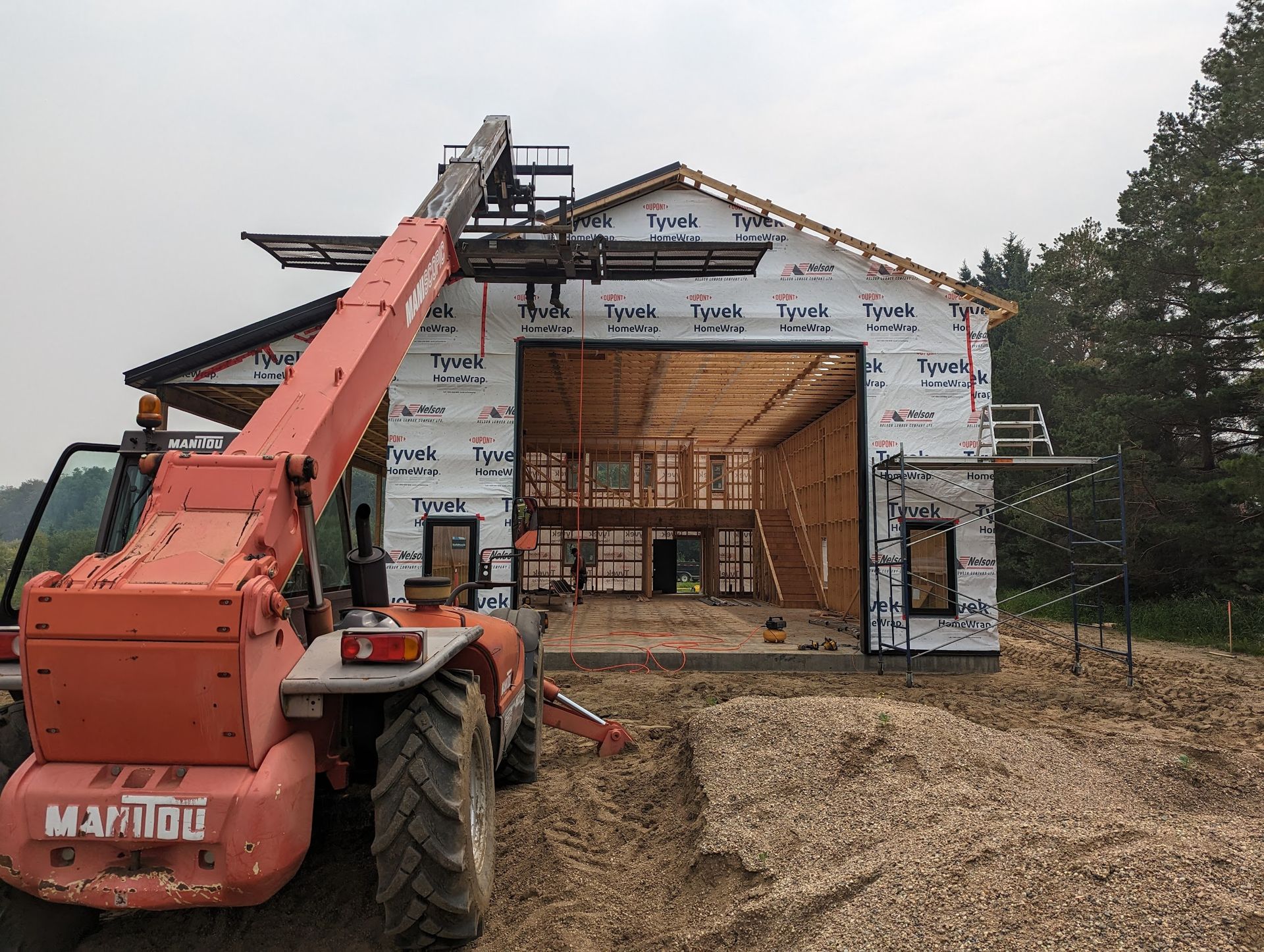 A tractor is parked in front of a building under construction.