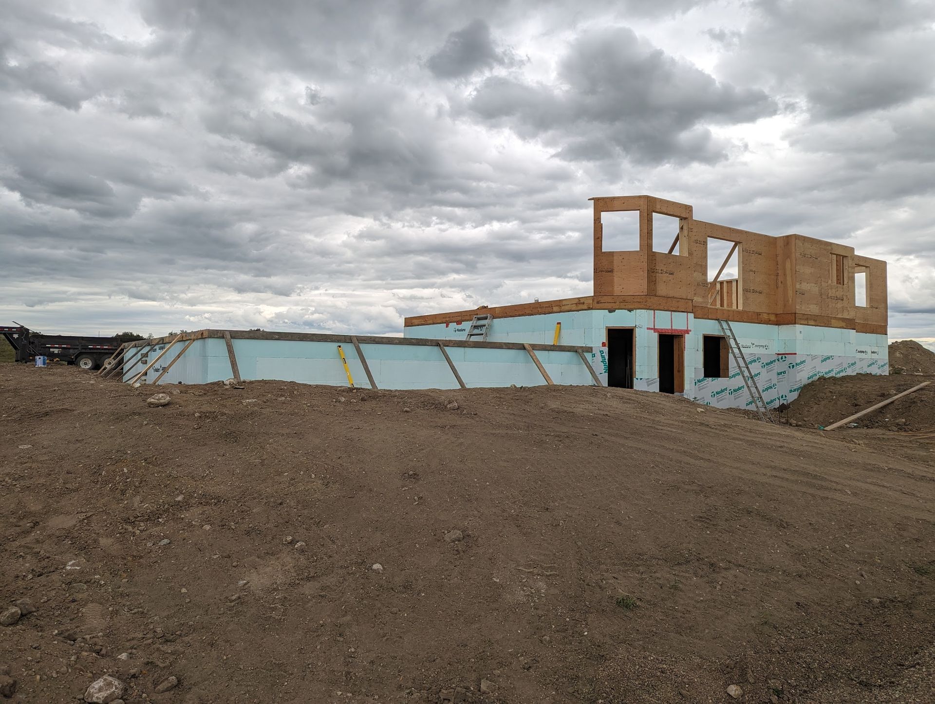 A house is being built on top of a dirt hill.