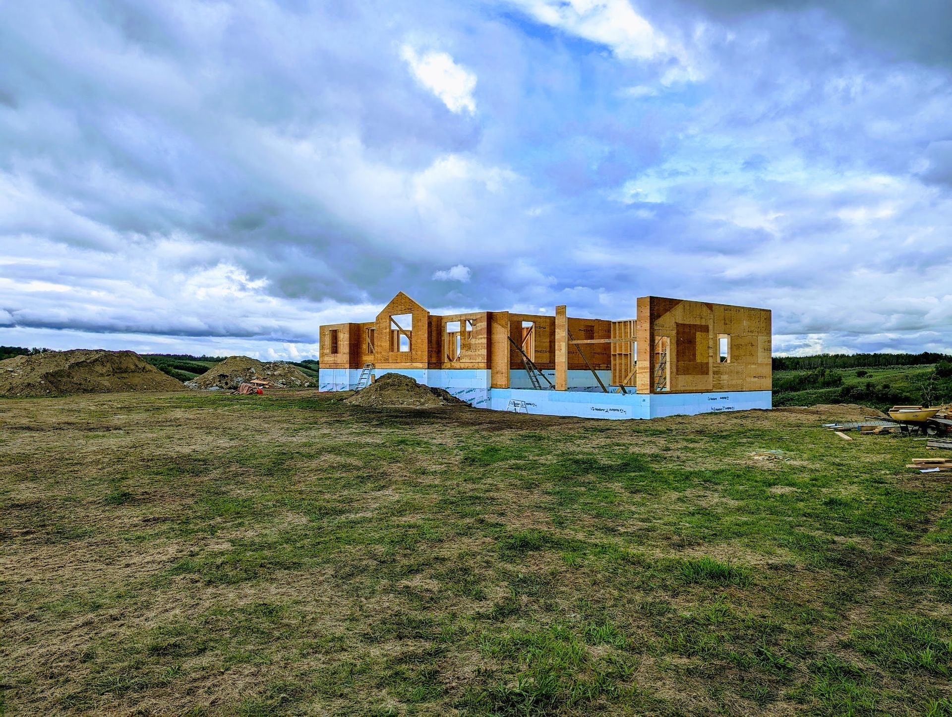 A house is being built in the middle of a grassy field.