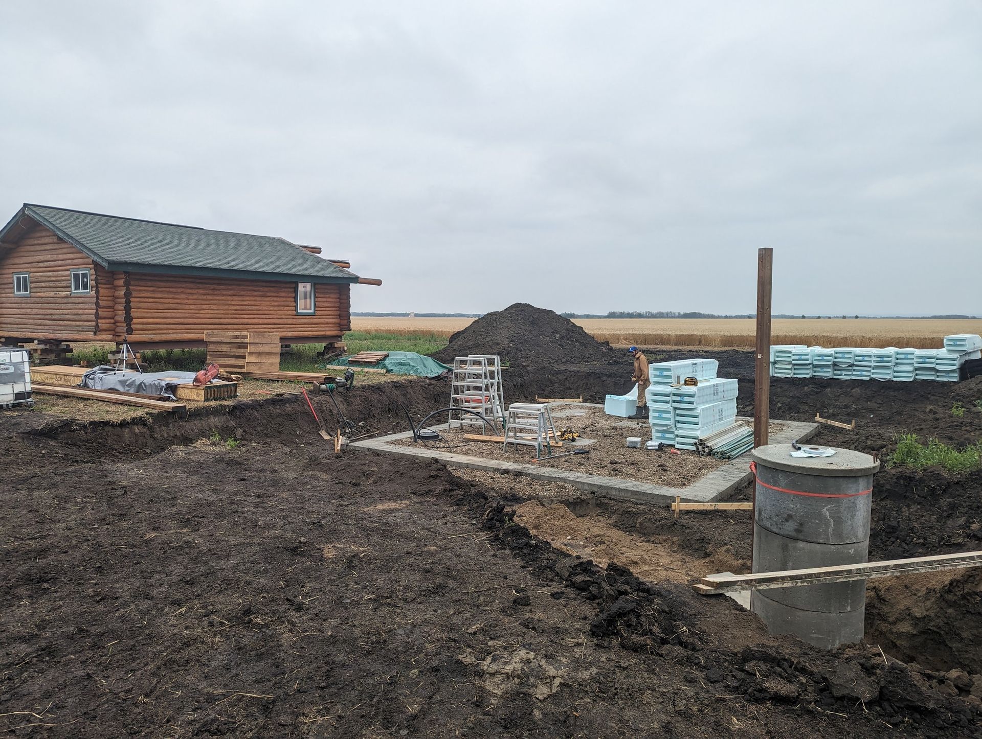 A house is being built in the middle of a dirt field.