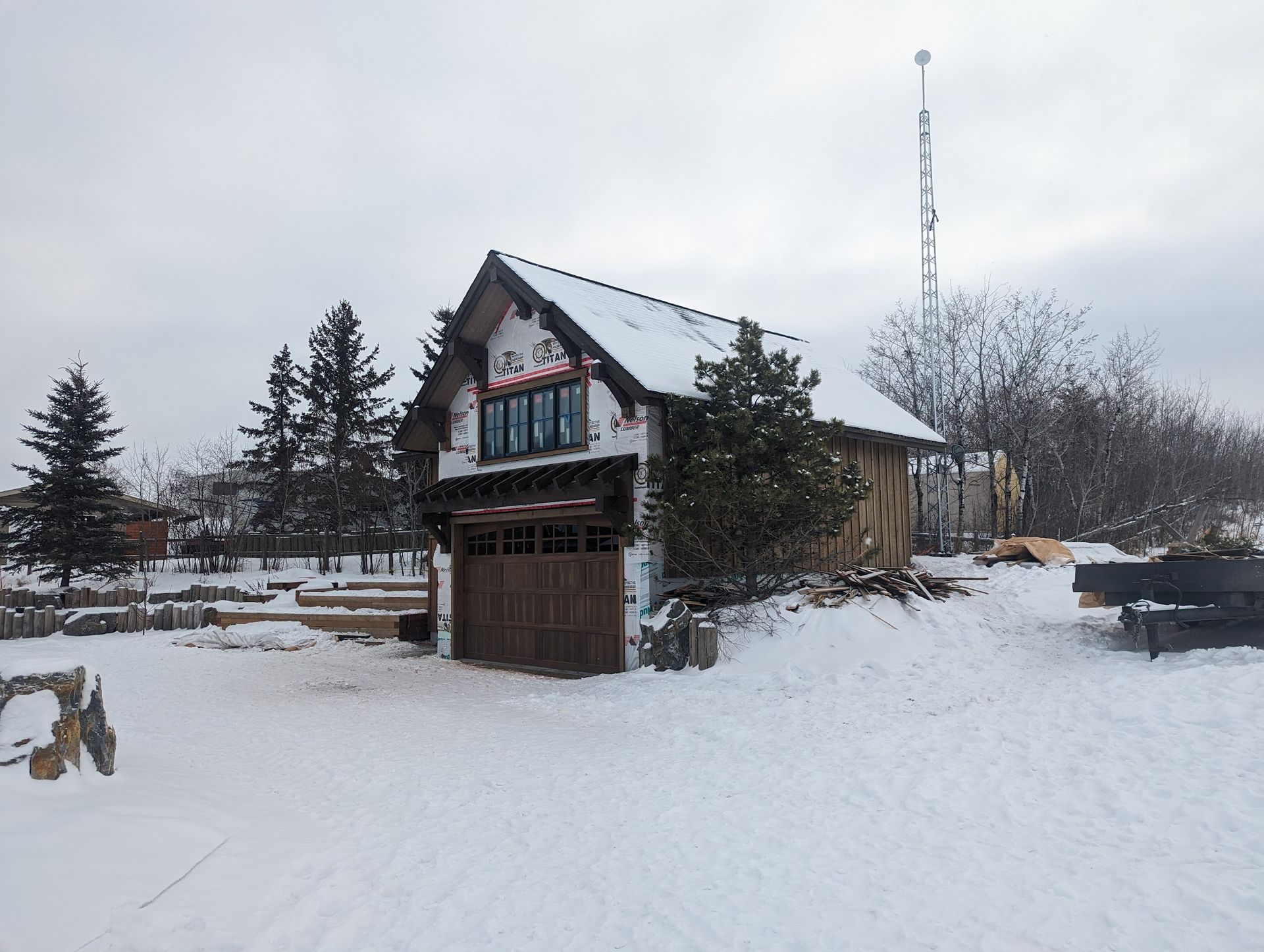 A small house in the snow with a large garage door