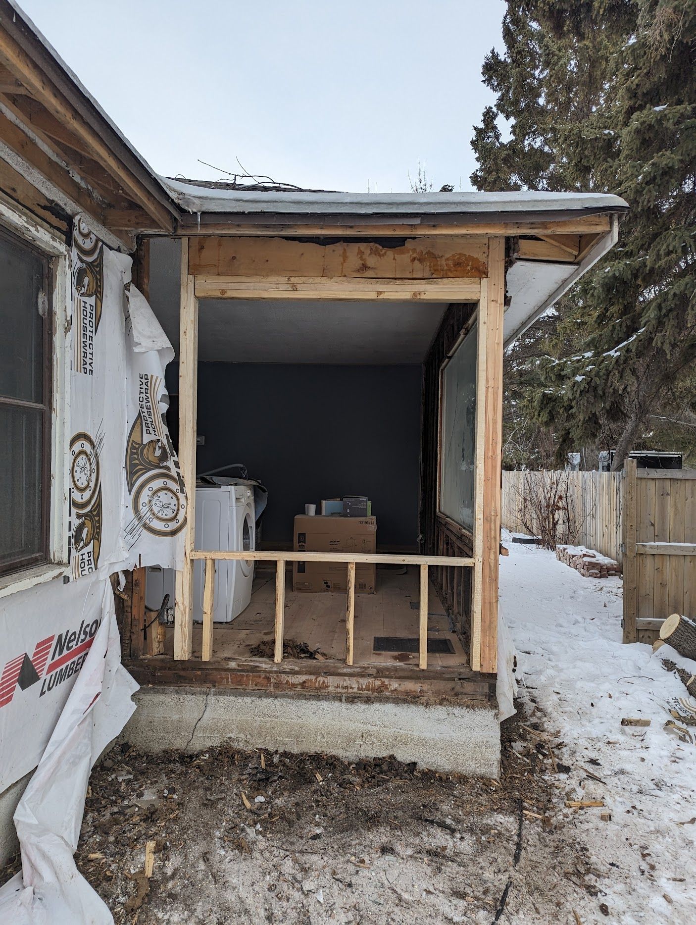 A house with a porch being built on the side of it.