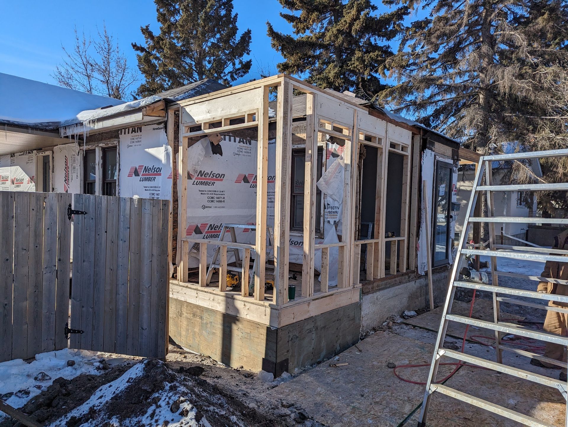 A house is being built with a ladder in front of it.