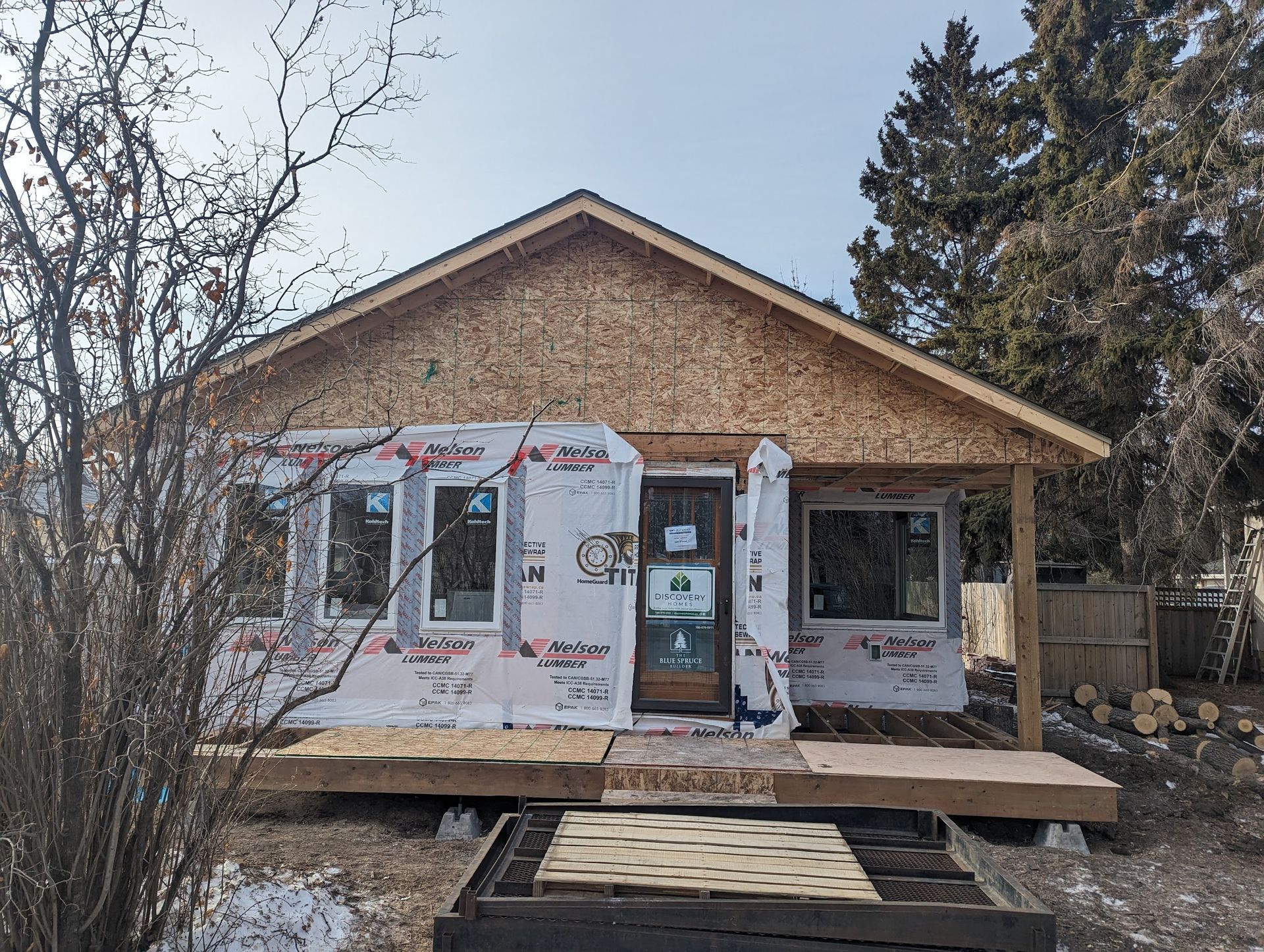 A small house is being built with plywood and styrofoam.