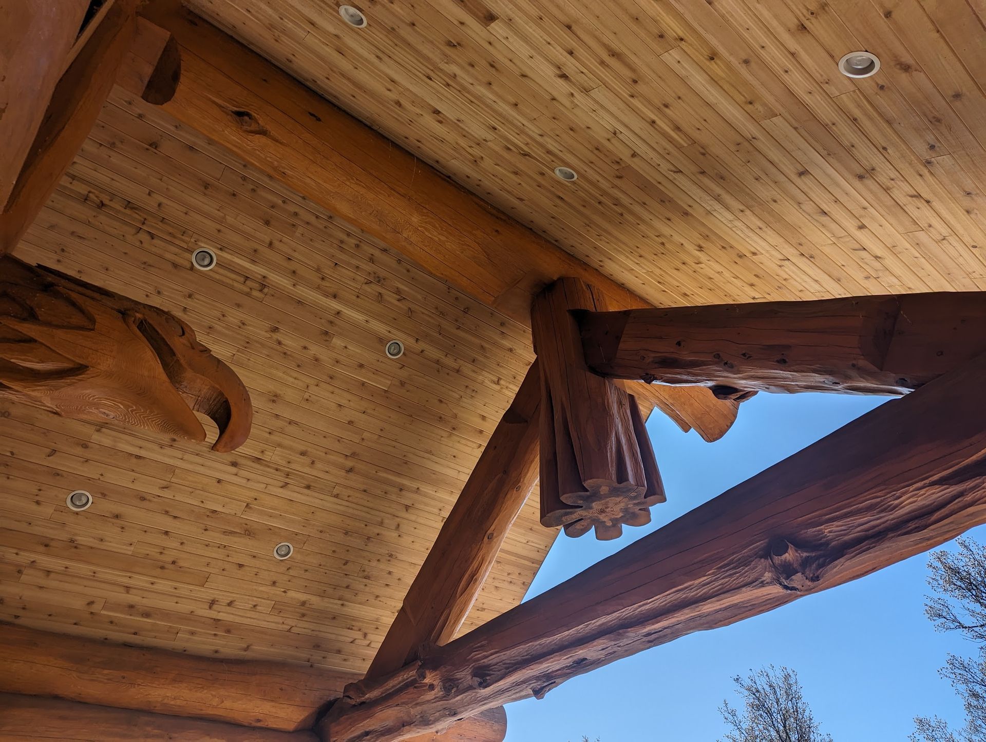 A wooden ceiling with a blue sky in the background