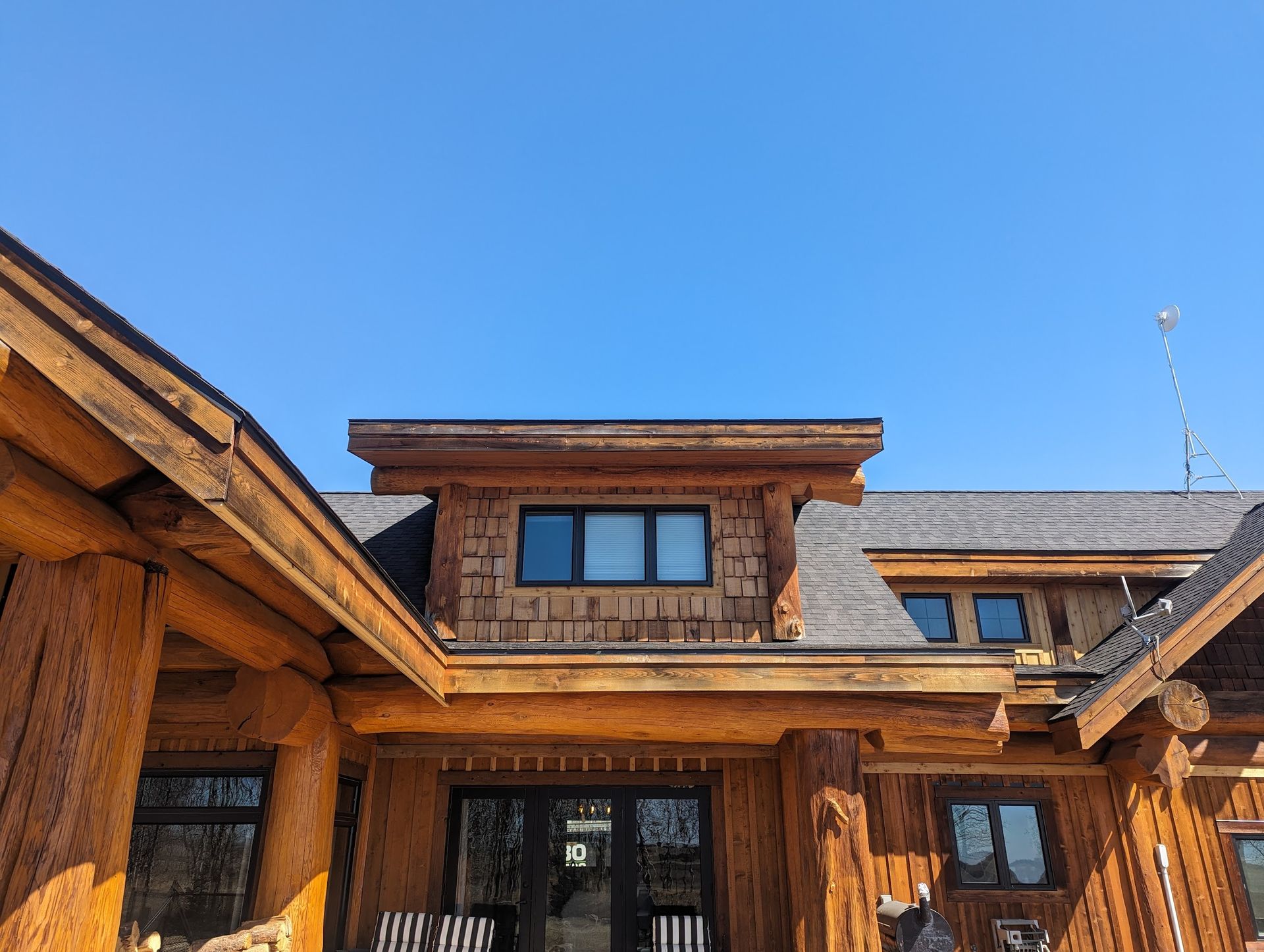 A large wooden house with a blue sky in the background.